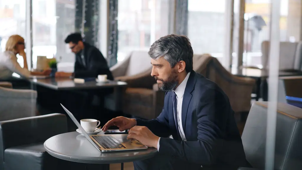 Sales professional messaging a decision-maker from a laptop
