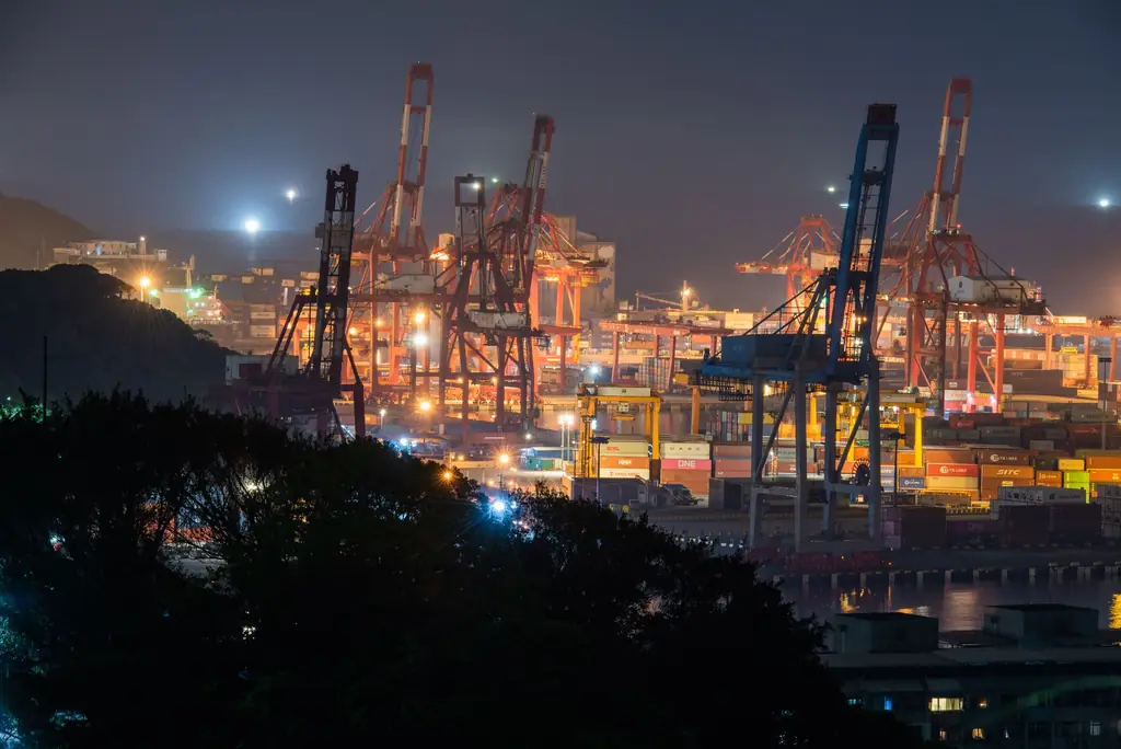 Container port at night with the city lights behind it